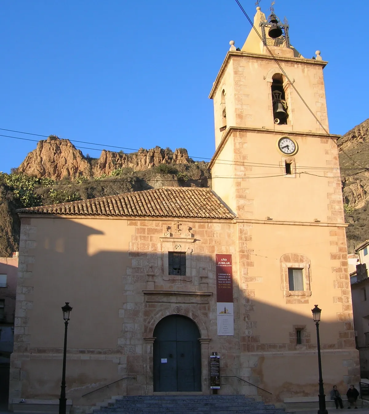 Iglesia de San Juan Evangelista en Blanca, con la peña del castillo al fondo